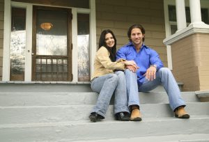 young couple with their new house. smiling and looking to camera